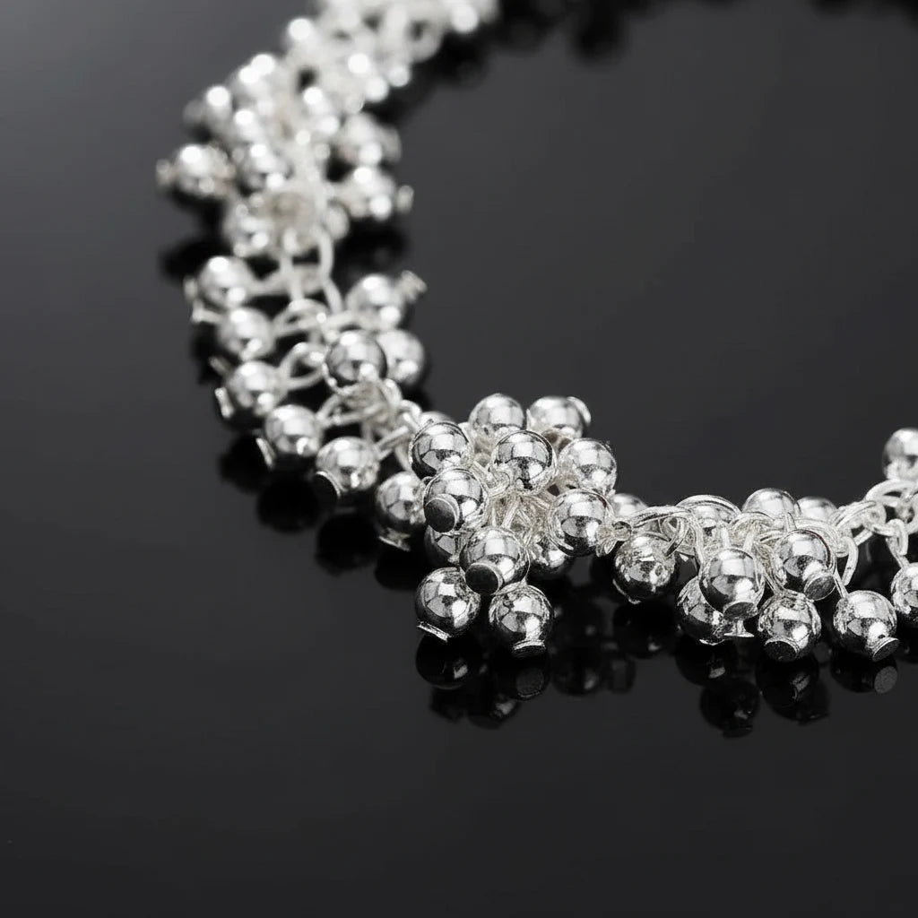 Close-up macro shot of the Silver Beaded Cluster Bracelet on a glossy black surface, emphasizing the reflective shine of the tightly packed silver beads and intricate clustered design | Oria Jewel