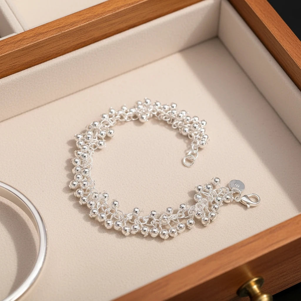 Silver Beaded Cluster Bracelet resting in a cream jewelry box with wooden edges, showcasing its full circular shape, textured bead clusters, and secure lobster clasp detail | Oria Jewel