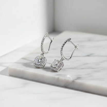 Silver Crystal Drop Huggie Earrings angled close-up on marble slab | OriaJewel