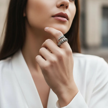 Silver Fishbone Ring worn on a woman’s hand near the face, showing the bold fishbone-inspired wrap design with layered spiky links and an oxidized silver finish in soft natural light | OriaJewel