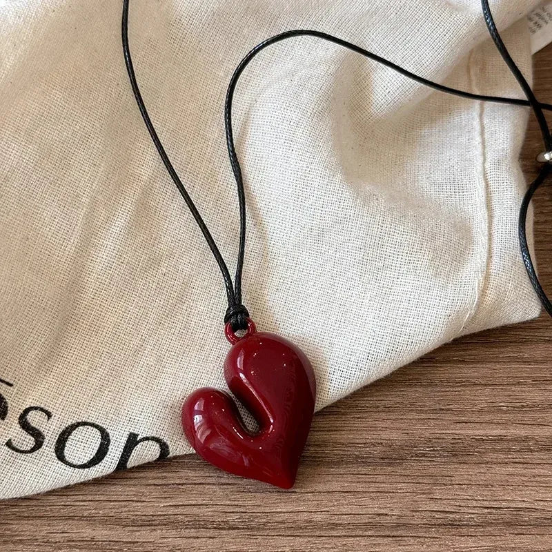Simple Heart Pendant Necklace displayed on a fabric surface with a black cord and a red heart-shaped pendant | Oria Jewel