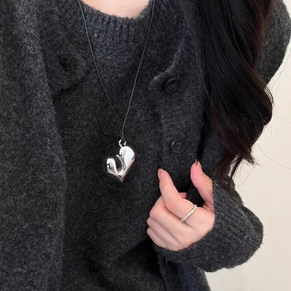 Simple Heart Pendant Necklace worn by a person in a grey sweater, showcasing a shiny heart-shaped pendant | Oria Jewel