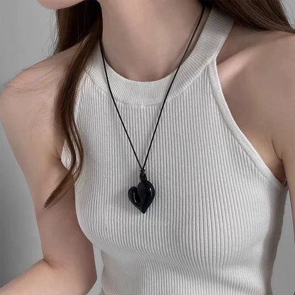Woman wearing a Simple Heart Pendant Necklace with a black heart charm on a simple black cord | Oria Jewel