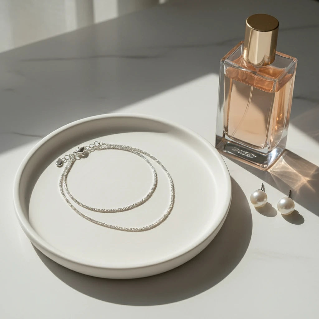 Sparkling Chain Necklace arranged on ceramic plate beside perfume bottle and pearl earrings | Oria Jewel