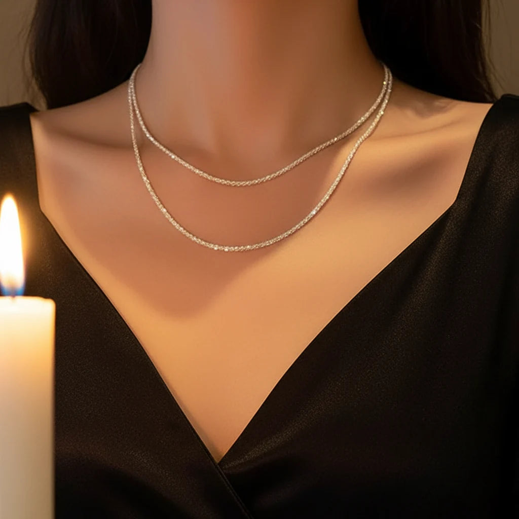 Sparkling Chain Necklace layered in silver against elegant black dress with candlelight glow | Oria Jewel