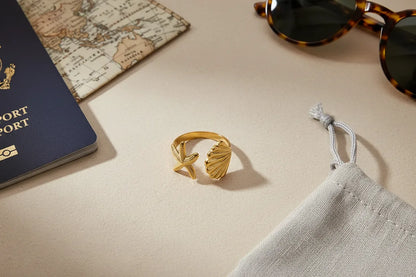 Starfish Gold Ring in a travel flat lay with passport, map, sunglasses, and pouch, sunlit scene with the ring centered as the hero | OriaJewel