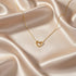 Gold-toned Sterling Silver Heart Chain Necklace on satin fabric — soft lighting accentuating heart-shaped pendant | Oria Jewel