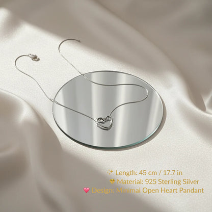Sterling Silver Heart Chain Necklace displayed on a mirror over satin fabric with elegant text showing specifications — 45 cm / 17.7 in length, 925 sterling silver material, and minimal open heart pendant design | Oria Jewel