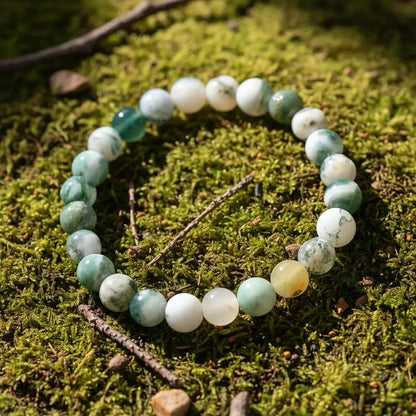 Nature shot of the Success Energy Stone Bracelet lying on lush green moss with small twigs, emphasizing its earthy tones and grounding, success-attracting crystal energy | Oria Jewel