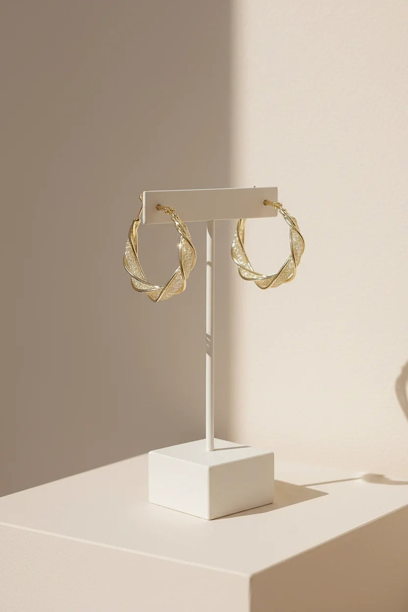 Twisted Crossover Hoop Earrings on white stand with warm shadows | OriaJewel