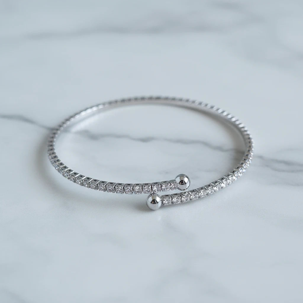 Silver Veluxa Pavé Wrap Cuff resting on a white marble surface, showing full circle of tightly set pavé stones | Oria Jewel