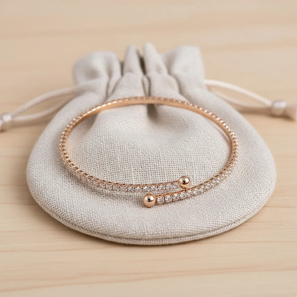Veluxa Pavé Wrap Cuff displayed on a soft beige drawstring pouch, highlighting its dainty, gift-ready minimalist design | Oria Jewel