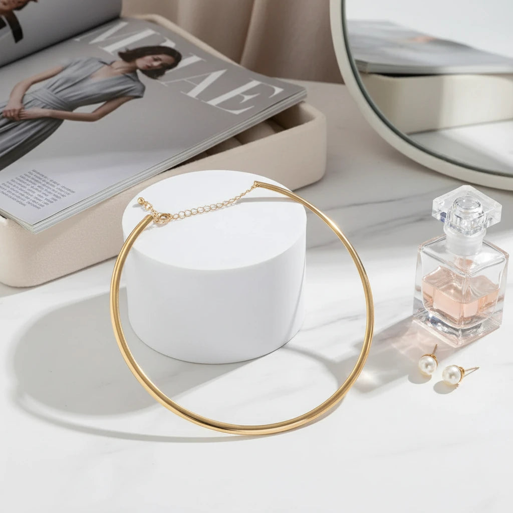 Vintage Choker Necklace in gold displayed beside perfume bottle, pearl earrings, and fashion magazine | Oria Jewel