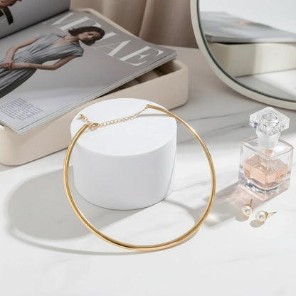 Vintage Choker Necklace in gold displayed beside perfume bottle, pearl earrings, and fashion magazine | Oria Jewel