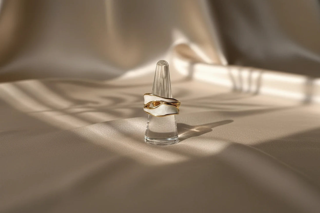 White Enamel Open Wave Ring displayed on a clear cone ring stand with warm window shadows, emphasizing the sculptural open wave silhouette and smooth white enamel finish | OriaJewel