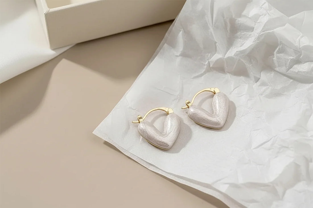 White Heart Huggie Hoop Earrings on tissue paper gift-style flat lay | OriaJewel