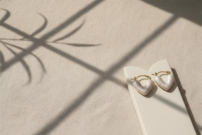 White Heart Huggie Hoop Earrings on display card with window shadows | OriaJewel