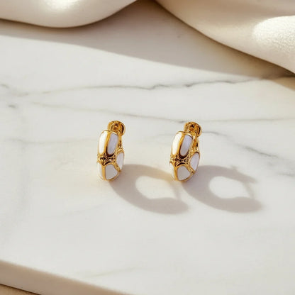 White Huggie Hoop Earrings on marble surface with soft shadow and satin | OriaJewel