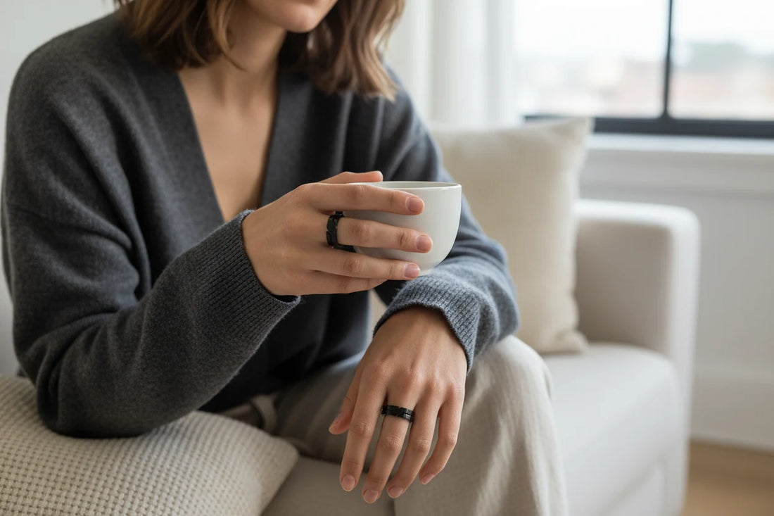 Wide Black Band Ring worn while holding a white coffee cup on a sofa, casual lifestyle shot with soft daylight and the ring visible on the hand for everyday styling | OriaJewel