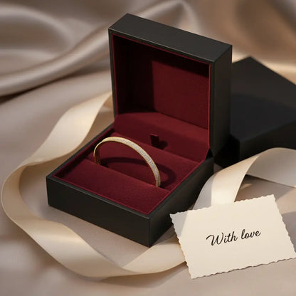 Luxurious presentation of the gold Xaria Pavé Wrist Cuff inside a black jewelry box lined with deep burgundy velvet, with a “With love” card and champagne-toned ribbon for romantic gifting | Oria Jewel