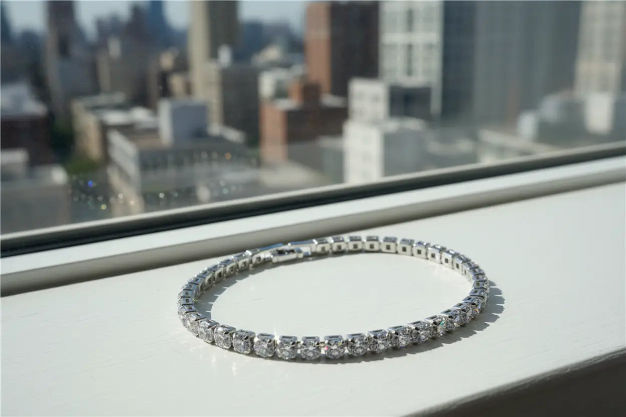 Silver cz tennis bracelet resting on a bright windowsill with a blurred city skyline in the background, each cubic zirconia stone catching the natural daylight and reflecting subtle rainbow flashes | Oria Jewel