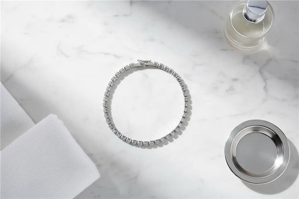 Top-down view of a cz tennis bracelet arranged in a perfect circle on a white marble countertop, styled with fluffy white towels and a silver dish for a clean, spa-like aesthetic | Oria Jewel