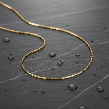 Water-resistant Flat Chain Choker displayed on dark stone surface with water droplets — durable and stylish | Oria Jewel