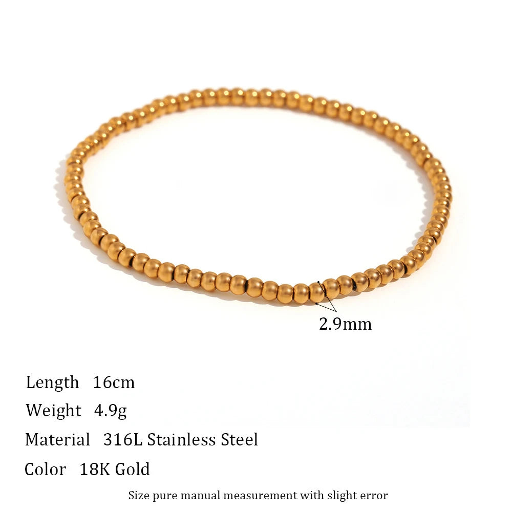 Product shot of a 2.9mm gold beaded stretch bracelet on a white background with printed measurements and details, highlighting the larger statement bead size and solid, weighty feel | Oria Jewel