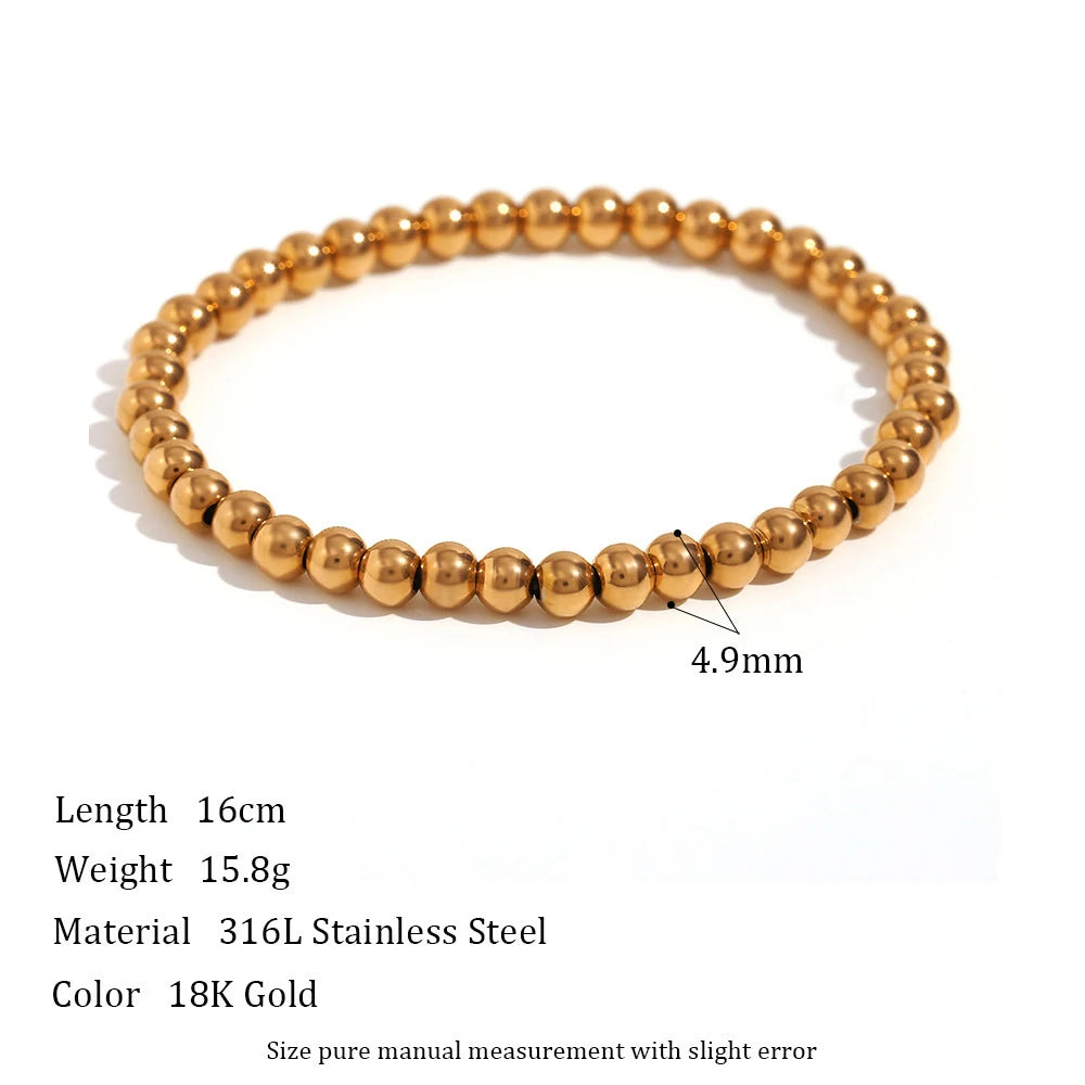 Product shot of a 4.9mm gold beaded stretch bracelet on a white background with specifications for length, weight, and 316L stainless steel material, emphasizing its medium bead size | Oria Jewel