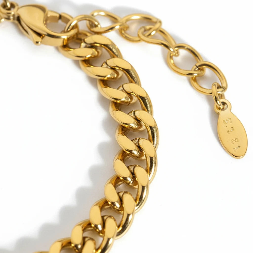 Macro close-up of polished links and extender clasp of a gold curb chain bracelet highlighting its smooth, reflective finish | Oria Jewel