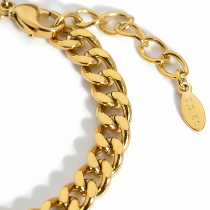 Macro close-up of polished links and extender clasp of a gold curb chain bracelet highlighting its smooth, reflective finish | Oria Jewel