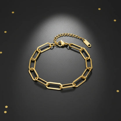 Elegant black background display of a shiny gold paperclip chain bracelet arranged in a circle for a luxe look | Oria Jewel