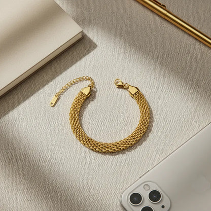 Overhead view of gold wheat chain bracelet styled next to smartphone, pen and notebook | Oria Jewel
