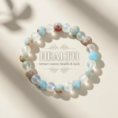 Flat-lay of the Luck &amp; Health Stone Bracelet framing the word “HEALTH – Attract career, health &amp; luck,” styled on a soft beige background | Oria Jewel