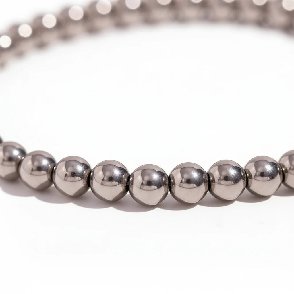 Macro close-up of a Silver Beaded Stretch Bracelet showing the polished stainless-steel beads in a tight row, highlighting the reflective surface and smooth rounded shape on a white backdrop | Oria Jewel