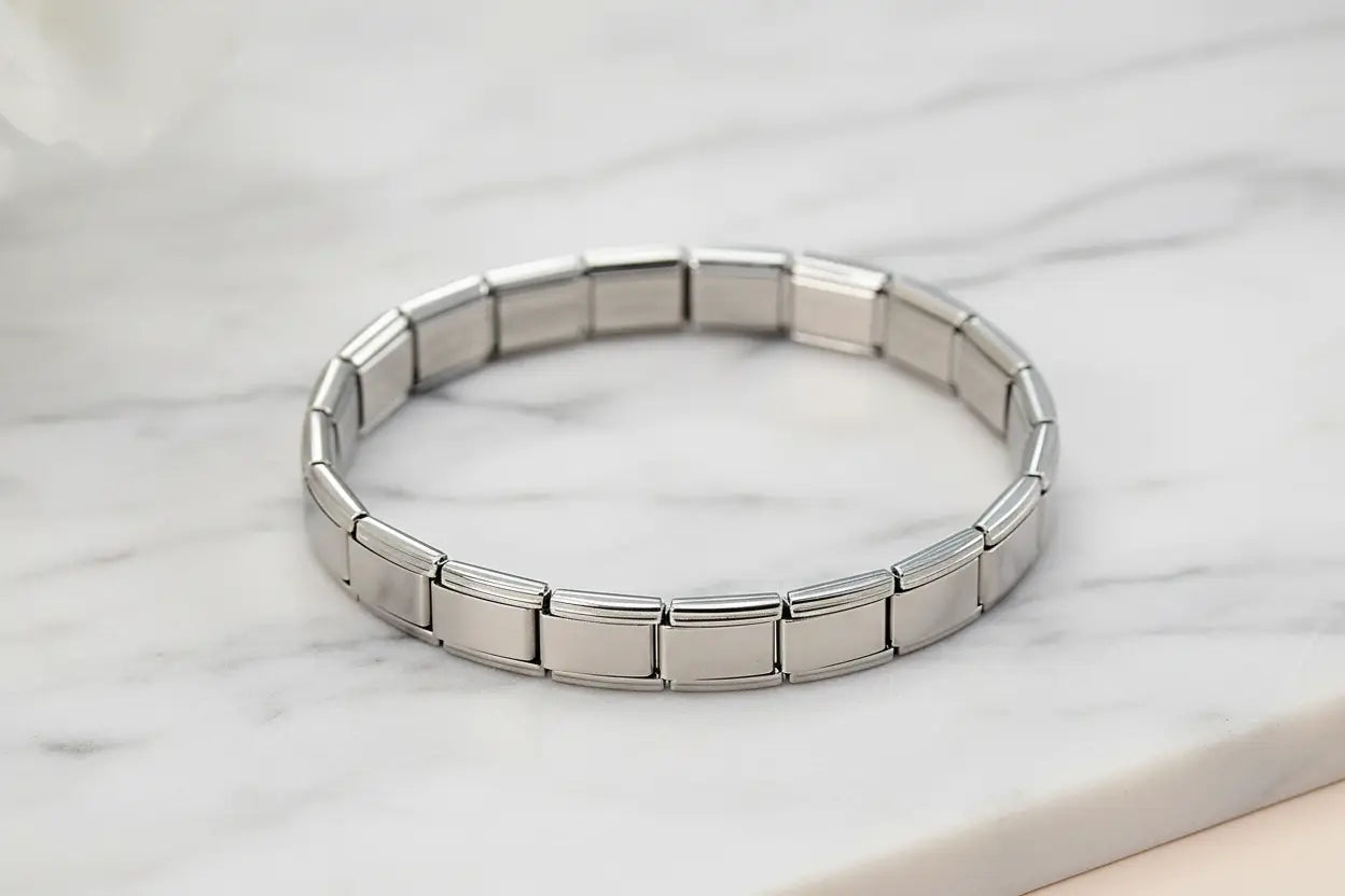 Close-up of a silver stainless steel stretch bracelets bracelets displayed on a white marble surface, showing the smooth rectangular links and polished finish that create a refined, timeless feel | Oria Jewel