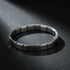 Dramatic studio image of a silver stainless steel stretch bracelets bracelets under a focused beam of light on a dark textured background, emphasizing its glossy metallic shine and flexible stretch construction | Oria Jewel