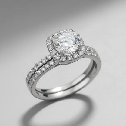 Soft Shine Halo Ring studio product photo on a clean grey background, angled view showing the raised halo setting, prongs, and pavé detailing across the band | OriaJewel